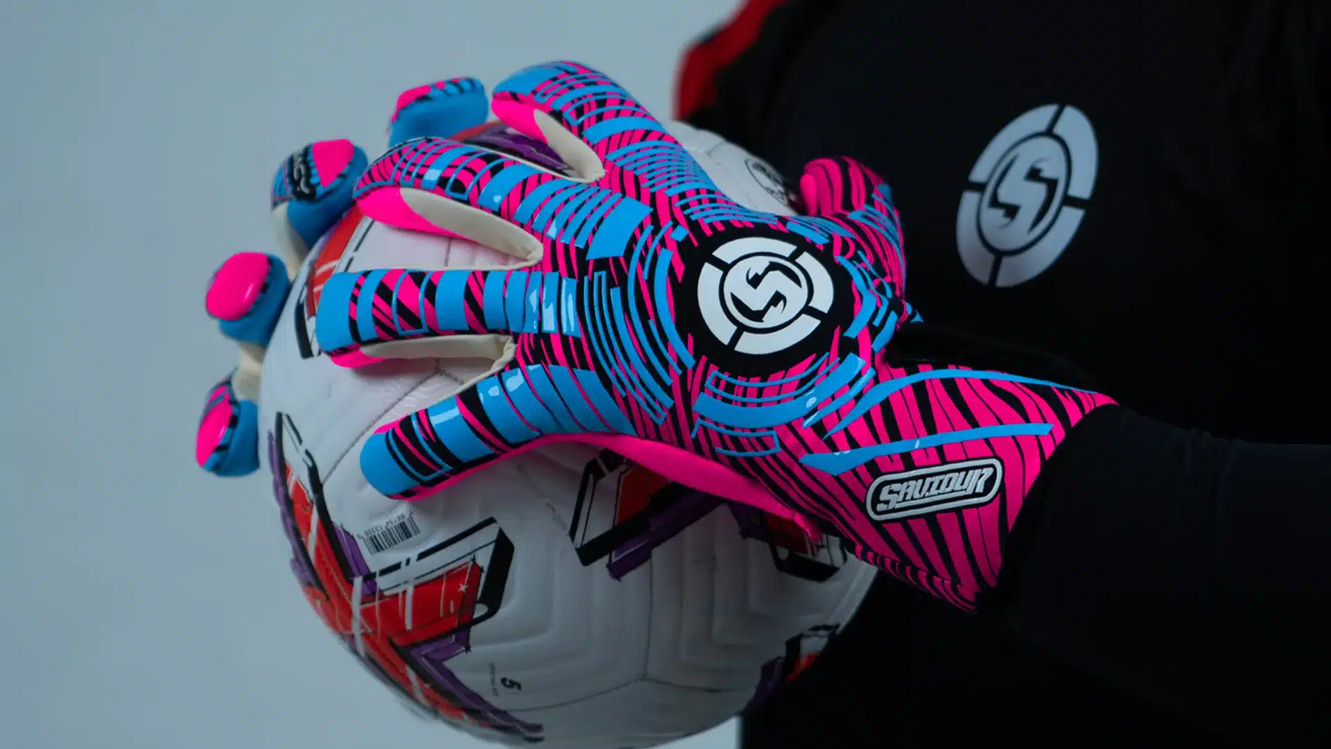 Unlock Peak Performance with Saviour GK Evo-Neg Gloves Now Back In Stock Sleek Saviour GK Evo-Neg goalkeeper gloves in eye-catching blue and pink, enhancing game performance back in stock