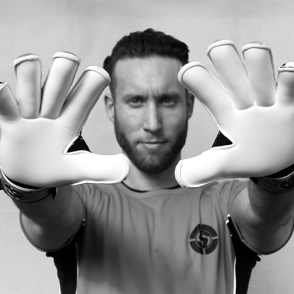 Professional goalkeeper poised in action, wearing advanced pro GK goalie gloves for superior game performance.