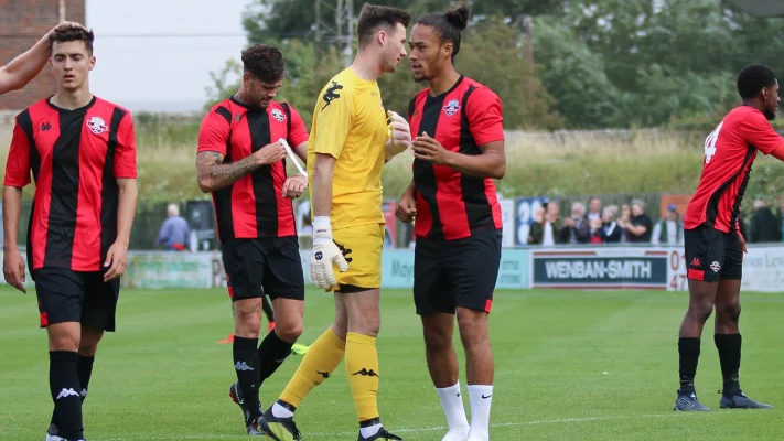 a goalkeeper at a tournament congratulating team mates on winning