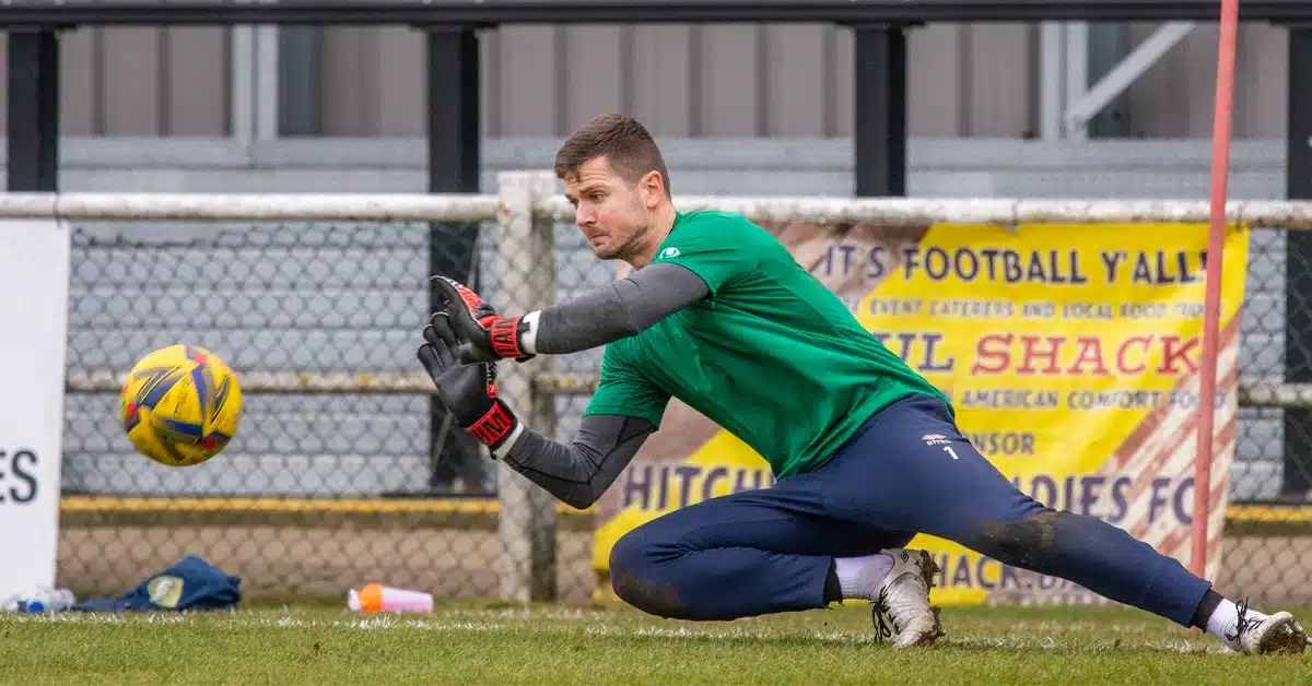 Goalkeeper in action, demonstrating one of the 4 reasons goalkeepers choose to parry or punch the ball during a match.