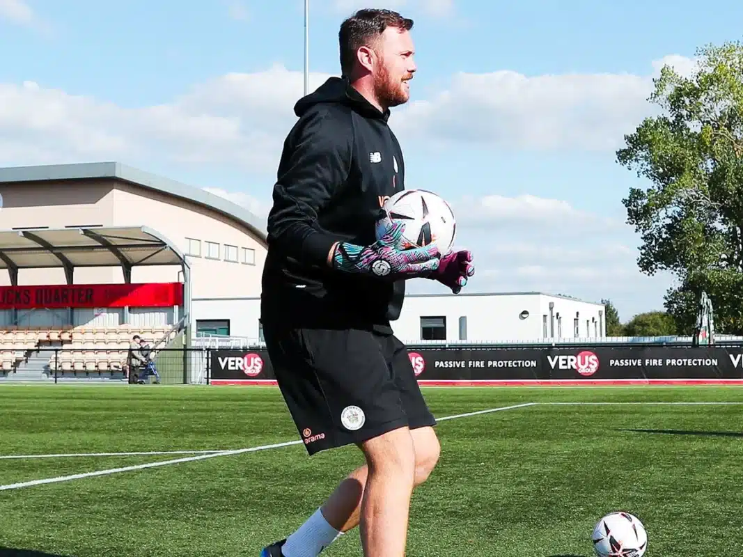 Goalkeeper coach guiding a player during training, emphasizing the crucial role of specialized coaching in soccer.