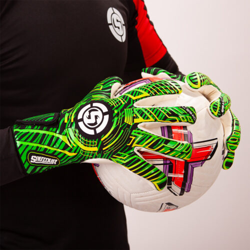 Adult goalkeeper saving a soccer ball wearing green soccer goalie gloves