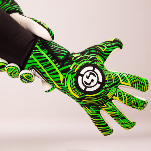 Young goalkeeper making a save with goalie gloves green in action