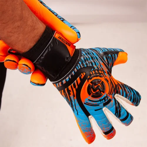 Young goalkeeper making a save in a match wearing specialized football goalie gloves for youth.
