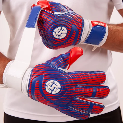 Goalkeeper in action wearing striking blue and red goalkeeper gloves.