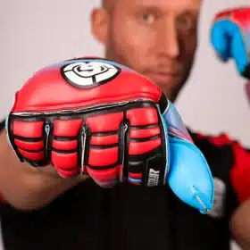 Close-up flat lay of red and blue soccer goalkeeper gloves on green grass.