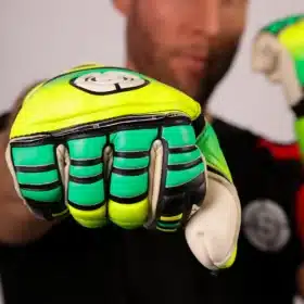 Bright yellow and green soccer GK gloves resting on a white goal net.